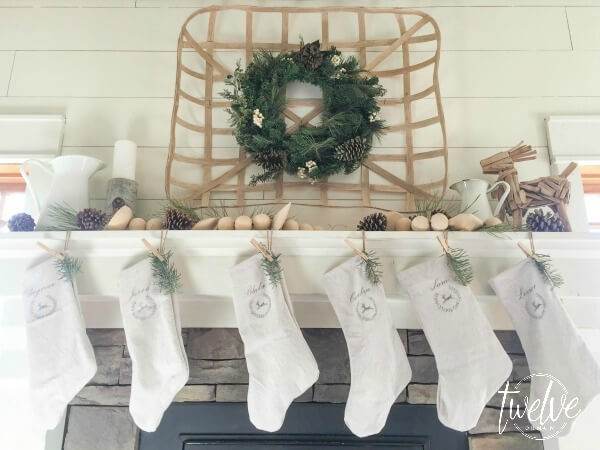 I love this farmhouse style Christmas mantel That driftwood reindeer is so perfect and those drop cloth stockings are amazing! farmhouse-christmas-mantel