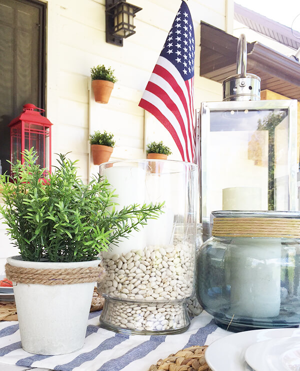 Farmhouse style patriotic outdoor tablescape for the 4th of July. Striped fabric, seagrass placemats, and red, white and blue, all on a chippy farmhouse table. Farmhouse style patriotic outdoor tablescape for the 4th of July. Striped fabric, seagrass placemats, and red, white and blue, all on a chippy farmhouse table.