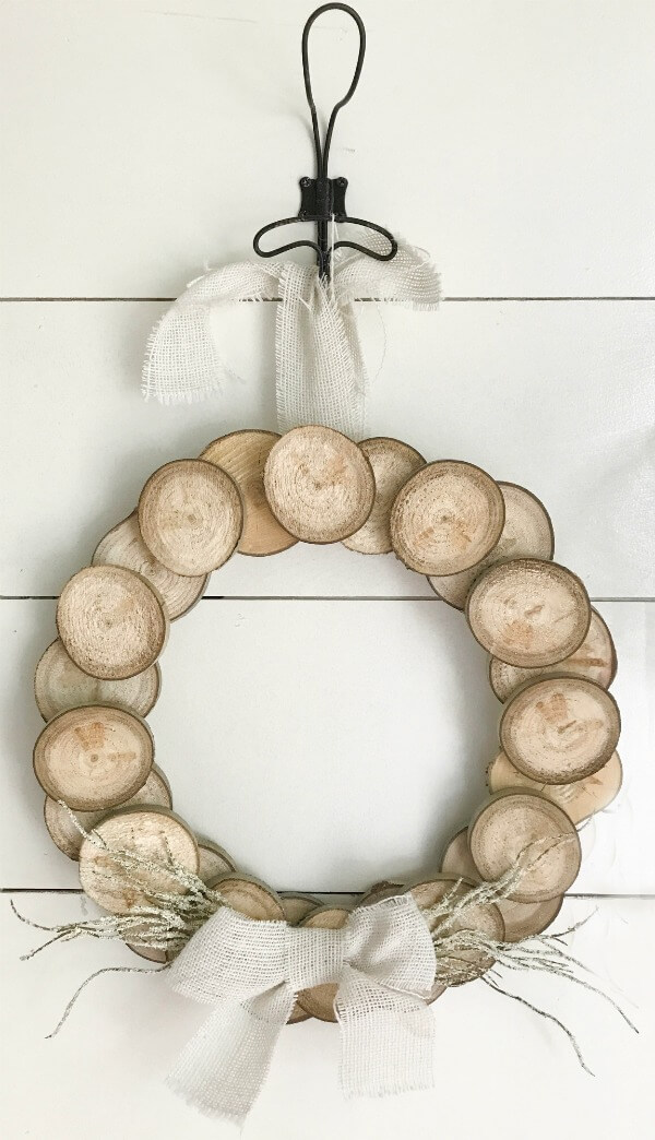 I love this easy DIY wood slice wreath! With its rustic wood detail and neutral farmhouse style its perfect for any space! These are so easy to make and they can look great for fall, or any time of year! Make one for yourself!