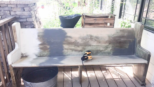 This incredible farmhouse style church pew is the perfect addition to this farmhouse porch! You have to see what it looked like before. With the addition of farmhouse pillows, crates, baskets, and galvanized tubs, this space is perfection.