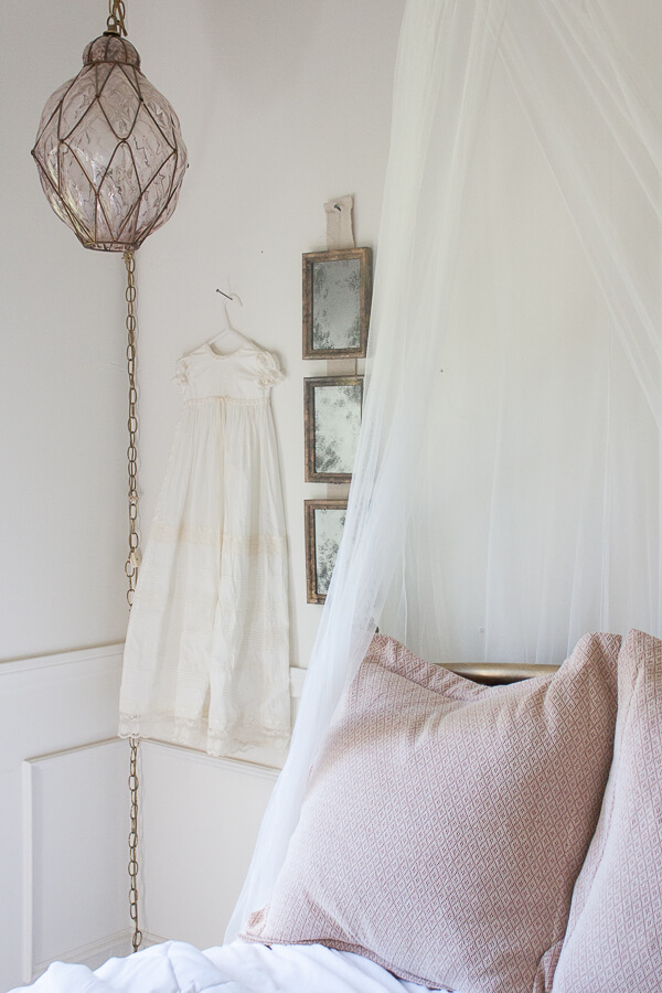 Little girls vintage french bedroom with vintage glass light and aged vintage mirrors made from old thrift store picture frames.