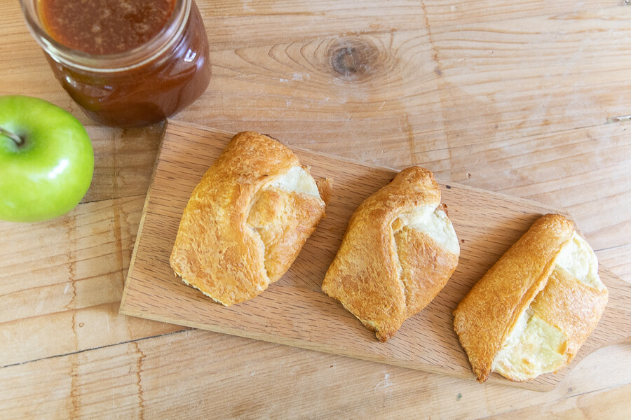 Sweet apple dessert with indulgent cream cheese and homemade caramel sauce wrapped in a crescent roll!