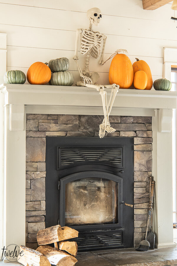 What a fun way to decorate for Halloween! Check out this amazingly simple and conversation starter Halloween mantel! This is so fun! A full sized posable skeleton along with some real pumpkins are the perfect Halloween mantel accessories!