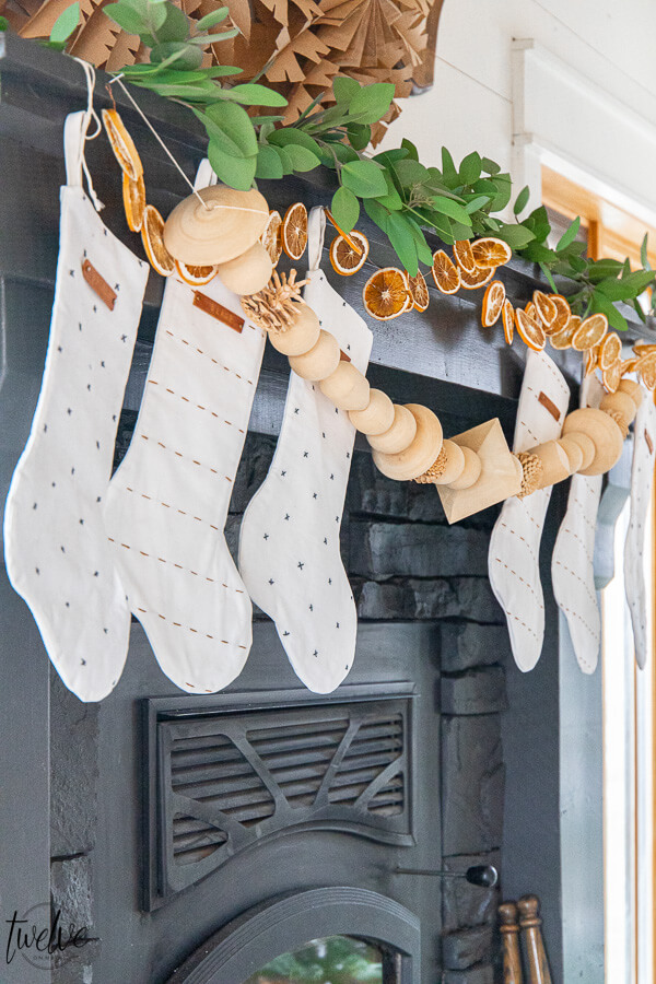 Gorgeous boho/Scandinavian holiday mantel complete with eucalyptus, dried orange slices, and wooden bead garland.