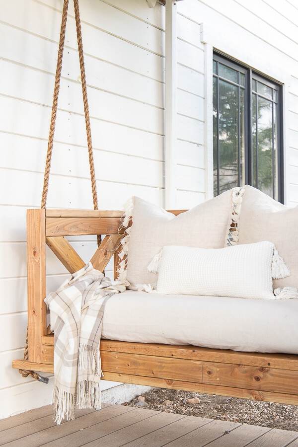 Make this easy DIY porch swing using these easy to follow building plans. This is stylish, and so cozy! Make sure to check it out!