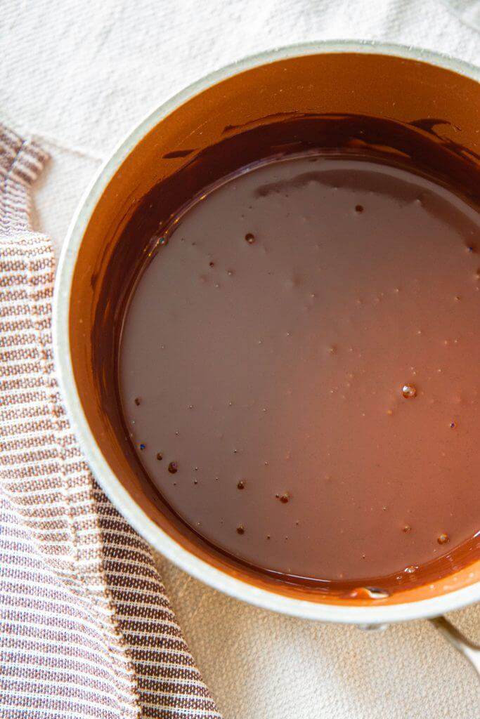 How to make a 2 ingredient chocolate sauce or chocolate ganache. This easy topping is the perfect chocolate sauce for ice cream, for cake,  and many other baked goods. With only 2 ingredients it is easy to make and can be stored in the fridge for a later use! Learn how to make it and what I love to use it on here! See more at www.twelveonmain.com