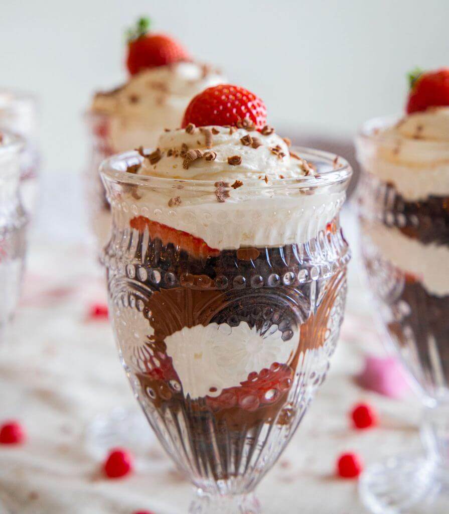 This is the best brownie trifle recipe. With the combination of brownies or chocolate cake, pudding/cool whip filling, strawberries, and homemade chocolate sauce, this is easy to make and looks amazing! It tastes amazing and is a sweet treat to make for Valentines Day or any day. Its a great Valentines dessert, and the individual trifles are adorable!