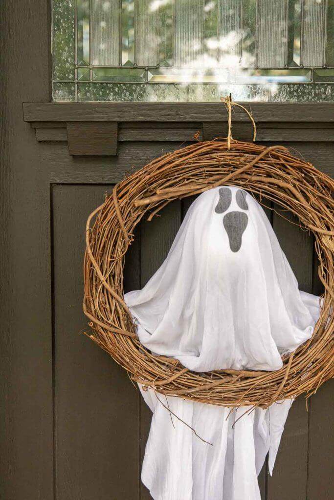 This ghost Halloween door wreath DIY using Dollar Tree items is the cutest and most affordable Halloween decor this year!!