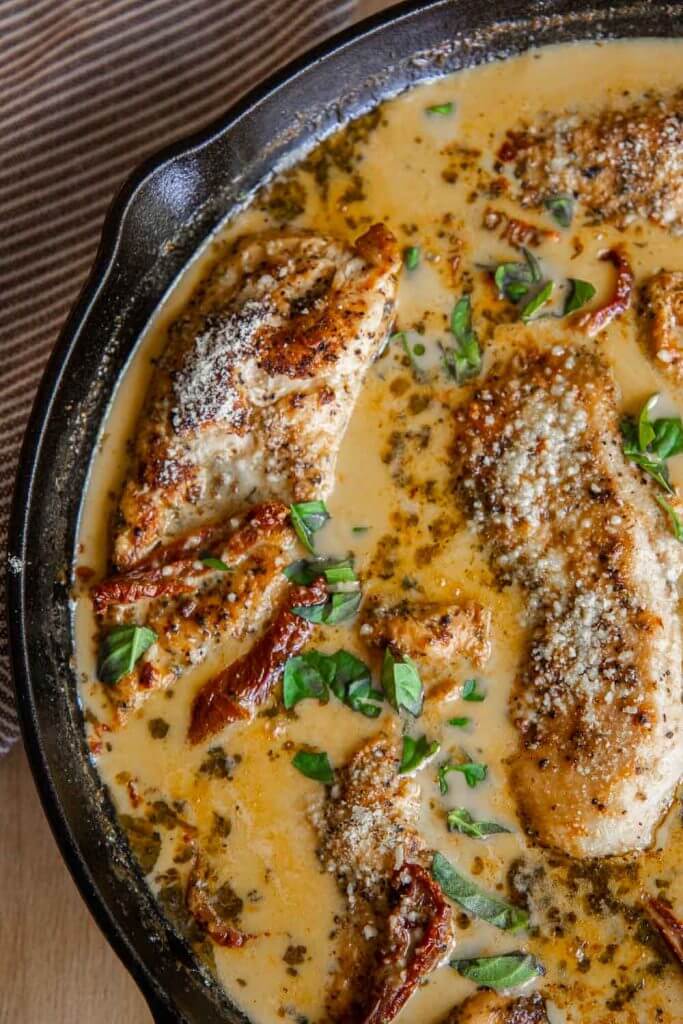 This amazing marry me chicken is on our our most popular dishes with a creamy sun-dried tomato sauce with garlic and parmesan. This chicken is bathed in a garlic and parmesan cream sauce and sun dried tomatoes. It is skillet cooked and finished in the oven with tender fall apart chicken breasts. Serve with pasta, or your favorite veggies side.