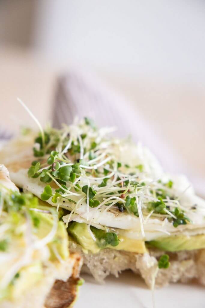 This hearty and healthy sourdough breakfast sandwich with eggs, avocado, microgreens, hot honey and sea salt is the perfect balanced breakfast. It is so full of flavor and is a perfectly balanced meal.