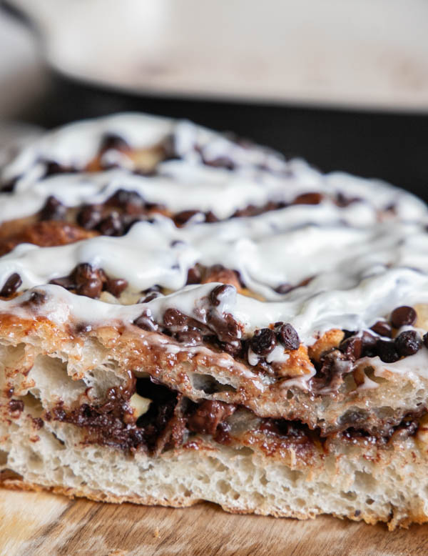 This amazing chocolate chip sourdough focaccia bread recipe is a glorious take on my regular sourdough focaccia bread. It is light and airy with a sweet chocolate chip filling and a drizzle of cream cheese icing.