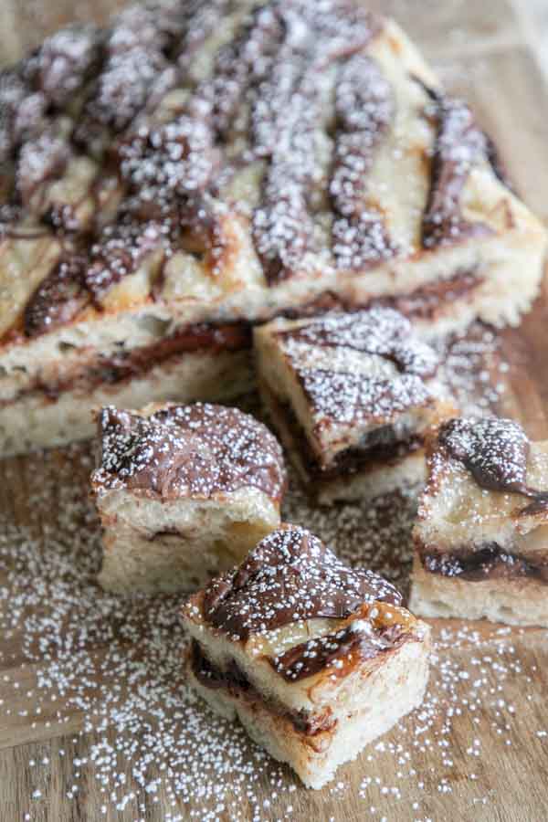 Golden sourdough focaccia bread swirled with rich Nutella, sliced and served on a wooden board