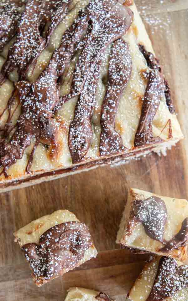 Golden sourdough focaccia bread swirled with rich Nutella, sliced and served on a wooden board