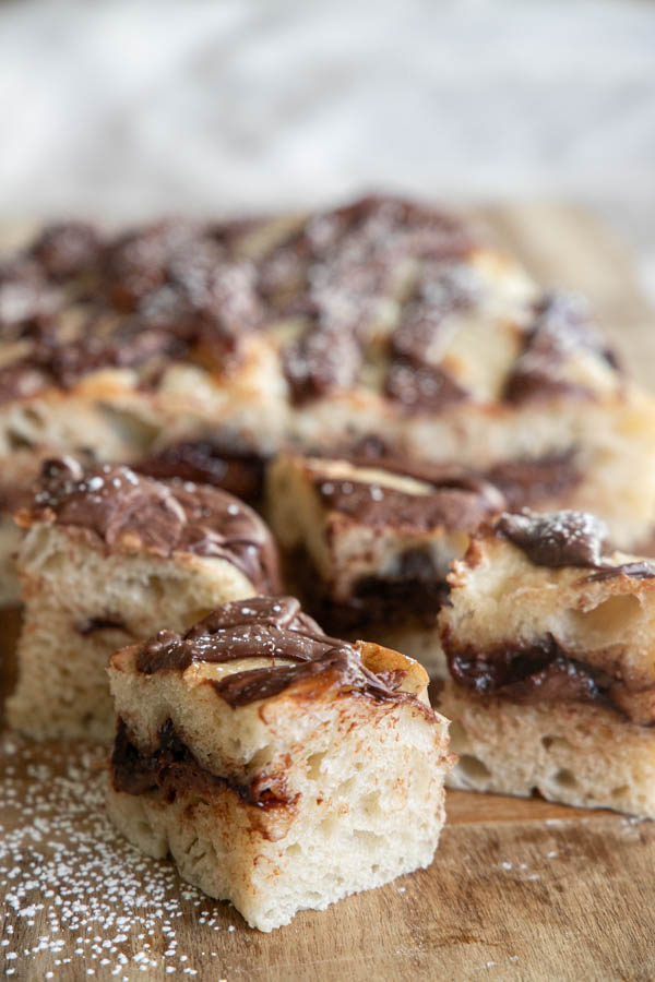 Golden sourdough focaccia bread swirled with rich Nutella, sliced and served on a wooden board